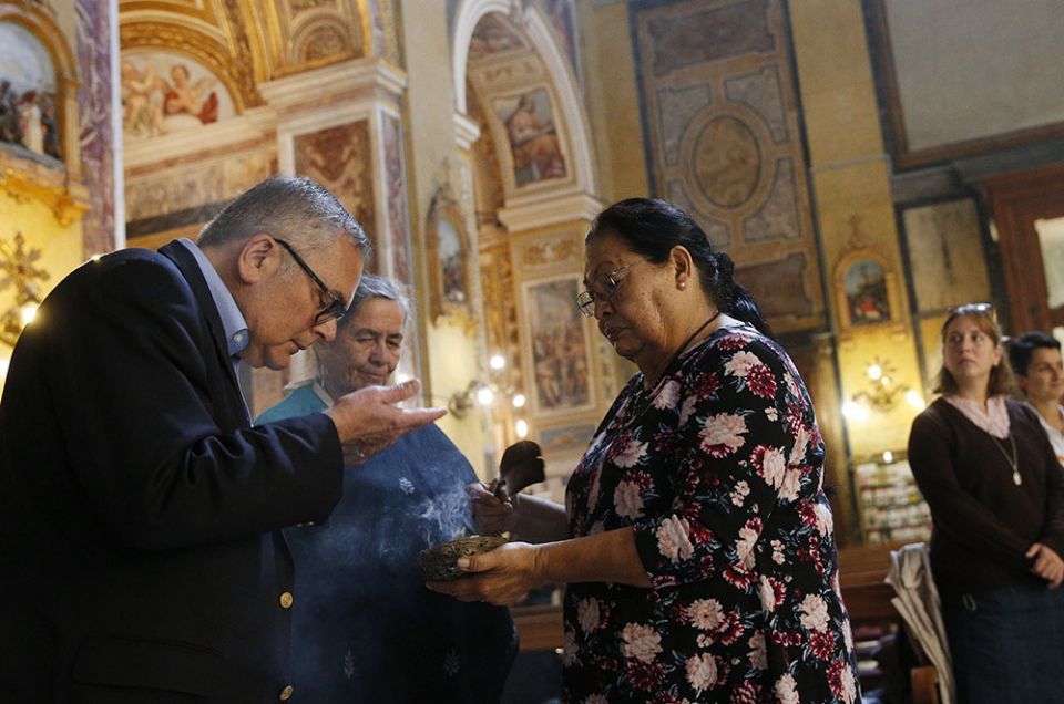 Richard Coll of the U.S. Conference of Catholic Bishops participates in a smudge ceremony as Rita Means, tribal council representative with the Rosebud Sioux Tribe, holds a smoking bowl at the Church of Santa Maria in Traspontina in Rome Oct. 18, 2019.