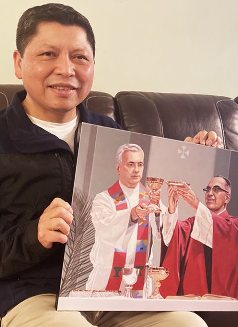 José Ortiz, de 53 años, sostiene una imagen de Rutilio Grande y san Oscar Romero en su casa en Los Ángeles mientras se sienta para un retrato el 8 de marzo. (Foto de RNS por Alejandra Molina)