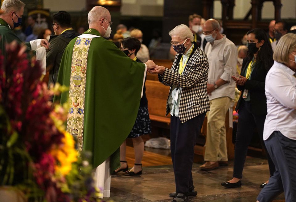 Loretto Sr. Jeannine Gramick receives Communion from Jesuit Fr. James Martin, author and editor at large of America Media, during a Mass at St. Paul the Apostle Church June 25 in New York City, for participants of the Outreach conference. (CNS)