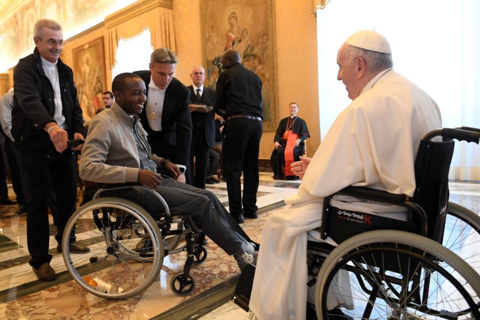 Pope Francis greets a cleric in a wheelchair during an audience with participants attending the general chapter of the Comboni Missionaries at the Vatican June 18, 2022. (CNS/Vatican Media)
