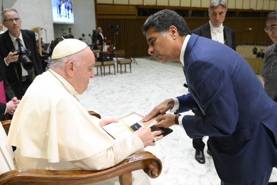 Pope Francis accepts materials from Punit Renjen, CEO of Deloitte Global, during an audience with a delegation from Deloitte Global in the Paul VI hall at the Vatican Sept. 22, 2022. 
